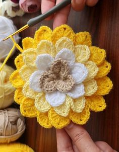 someone is crocheting a flower with yarn