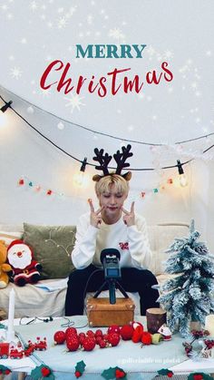 a woman sitting on top of a couch in front of a christmas tree and presents