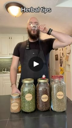 a man standing in front of jars filled with spices