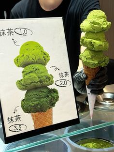 a man holding up an ice cream cone with green toppings on it in front of some bowls