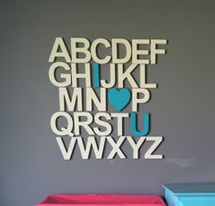 the letters are cut out of paper and placed on top of each other in front of a gray wall