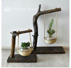 two hanging planters with plants in them on wooden stands, one is made out of branches