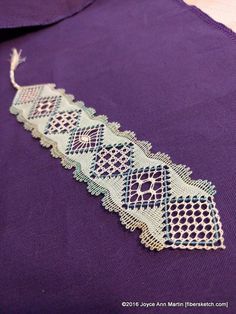 a close up of a purple shirt with an intricate lace design on the collarline