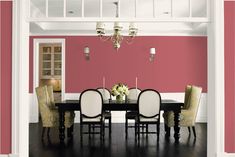 a dining room with blue walls and white chairs