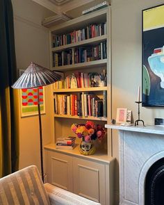 a living room filled with furniture and a fire place in front of a book shelf