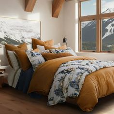 a bedroom with a large window overlooking the mountains and snow - capped peaks is pictured in this image