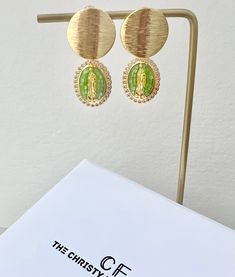 Our Divine gold filled earrings are one of a kind pieces. Handcrafted, gold-filled charms of the Virgin Mary in a light green mosaic opal gemstone and framed in cz micro pave crystals. Made to pair with our Divine Bracelet, Holy Necklace and Miracle Rings to create a custom curated and chicly divine look! 2 inch drops Green Jeweled Gold-plated Earrings, Gold Drop Earrings With Stones, Green Plated Drop Earrings, Green Dangle Jewelry With Plating, Gold Plated Green Jeweled Jewelry, Green Mosaic, The Virgin Mary, Bold Jewelry, Gold Filled Earrings