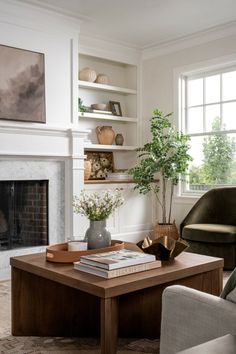 a living room filled with furniture and a fire place in front of a large window