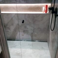 a walk in shower sitting inside of a bathroom next to a wall mounted faucet