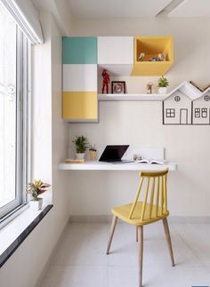 a yellow chair sitting in front of a window next to a desk with a laptop on it