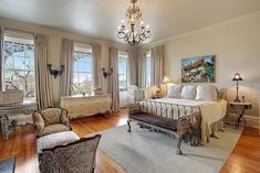 a bedroom with hardwood floors and chandelier