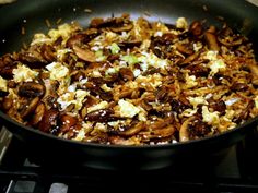 mushrooms, eggs and onions cooking in a skillet on the stove with other ingredients