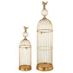 two gold birdcages sitting next to each other on top of a white surface