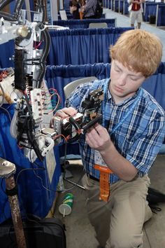 a young boy is working on an electronic device