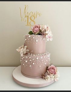 a three tiered cake with pink flowers on top