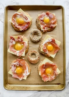 some food is laying out on a baking sheet with doughnuts and an egg in the middle