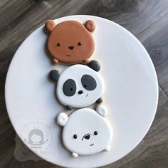 there are two cookies shaped like pandas on the cake platter, one is brown and one is white