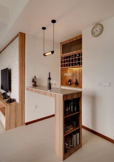 a room with a bar, shelves and a clock on the wall above it that has wine bottles in it