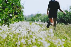 a person running through a field with tall grass