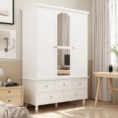 a white armoire in a bedroom next to a desk