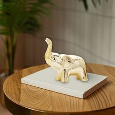 an elephant figurine sitting on top of a wooden table