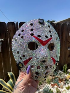 someone is holding up a mask that looks like it has been made out of crystals