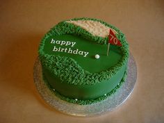 a green birthday cake with a golf ball and flag on the top that says happy birthday