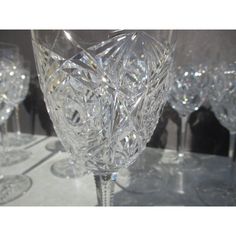 several crystal wine glasses are lined up on a table