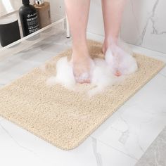 a person standing on top of a bathroom rug with water coming out of the floor