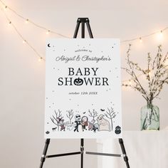 a baby shower sign sitting on top of a easel