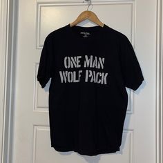 Novelty T-Shirt L New Unworn The Hangover One Man Wolf Pack Black Slogan Tops For Fan Merchandise, Black Cotton Fan Apparel Tops, Black Fan Apparel T-shirt With Text Print, Black Fan Apparel Top With Text Print, Black Slogan Fan Apparel Top, Cotton Slogan T-shirt Fan Apparel, Cotton Slogan T-shirt For Fan Apparel, Cotton Slogan T-shirt For Fans, Cotton Fan Apparel T-shirt With Slogan