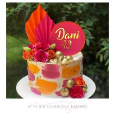 there is a colorful cake with flowers on the top and an orange fan next to it