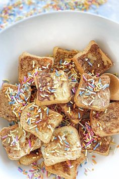 a white bowl filled with toast and sprinkles on top of a table