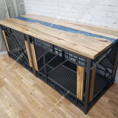 a large wooden table sitting on top of a hard wood floor next to a white brick wall