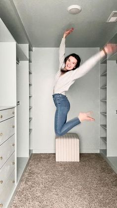 a woman jumping up into the air in a closet