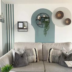 a living room filled with furniture and green plants on top of the couch's back