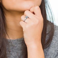 a close up of a person wearing a ring with a diamond on it's finger