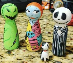 three painted wooden dolls sitting on top of a counter next to a cat figurine