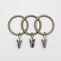 three metal key chains with two letters on each one and an arrow in the middle