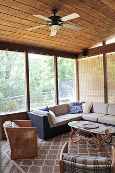 a living room filled with furniture under a wooden ceiling mounted to the side of a wall