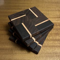 three wooden coasters stacked on top of each other with brown and black squares in the middle