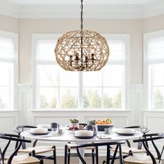 a dining room table with four chairs and a chandelier hanging from the ceiling