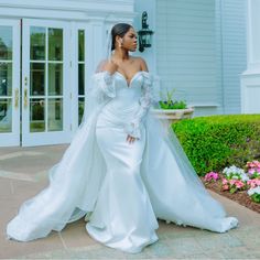 a woman in a wedding dress standing outside