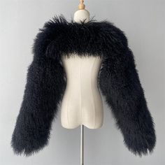 An interested cropped coat made of mongolian fur for the ultimate cool look to add to your wardrobe. Long Fur Coat With Feather Trim For Winter, Winter Fur Coat With Feather Trim And Long Sleeves, Winter Faux Fur Coat With Feather Trim, Long Sleeve Fur Coat With Feather Trim For Winter, Faux Fur Long Sleeve Outerwear With Feather Trim, Fall Fur Coat With Feather Trim For Cold Weather, Faux Fur Outerwear With Feather Trim And Long Sleeves, Black Winter Fur Coat Fluffy, Black Fluffy Fur Coat For Winter