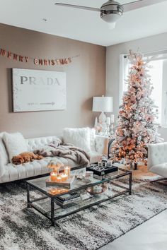 the living room is decorated for christmas with white furniture and a pink tree in the corner