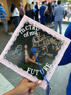 a person holding up a graduation cap with pictures on it