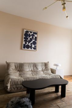 a living room with a futon couch and coffee table in front of a window