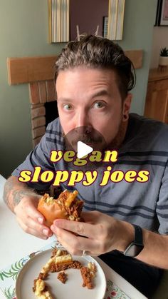 a man holding up a sandwich in front of his face with the words vegan sloppy joes on it