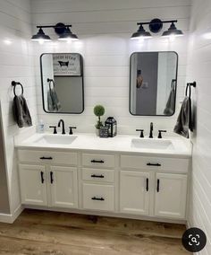 a white bathroom with two sinks and mirrors