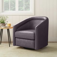 a purple chair sitting next to a table with a potted plant on top of it